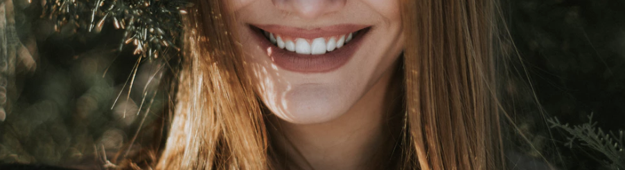 A woman with healthy, white teeth smiles after a root canal.