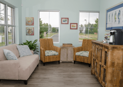 The waiting area for patients features a coffee machine, comfortable seating, and lots of sunlight.